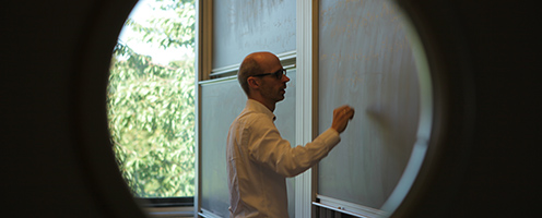 Male professor writing on a blackboard