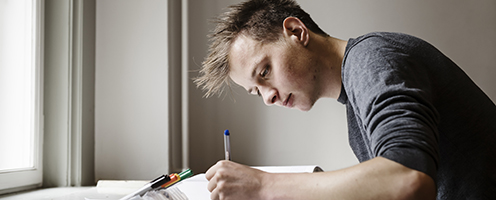 Student writing. Photo: Jakob Dall